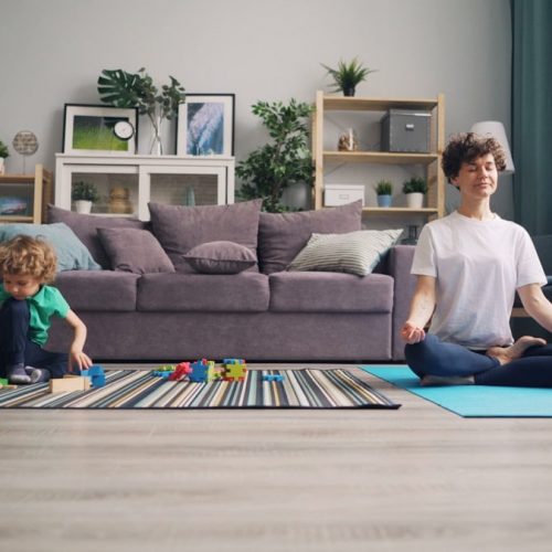 a woman and a child sitting on a rug in a living room