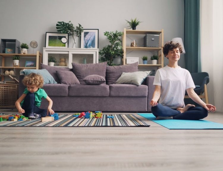 a woman and a child sitting on a rug in a living room